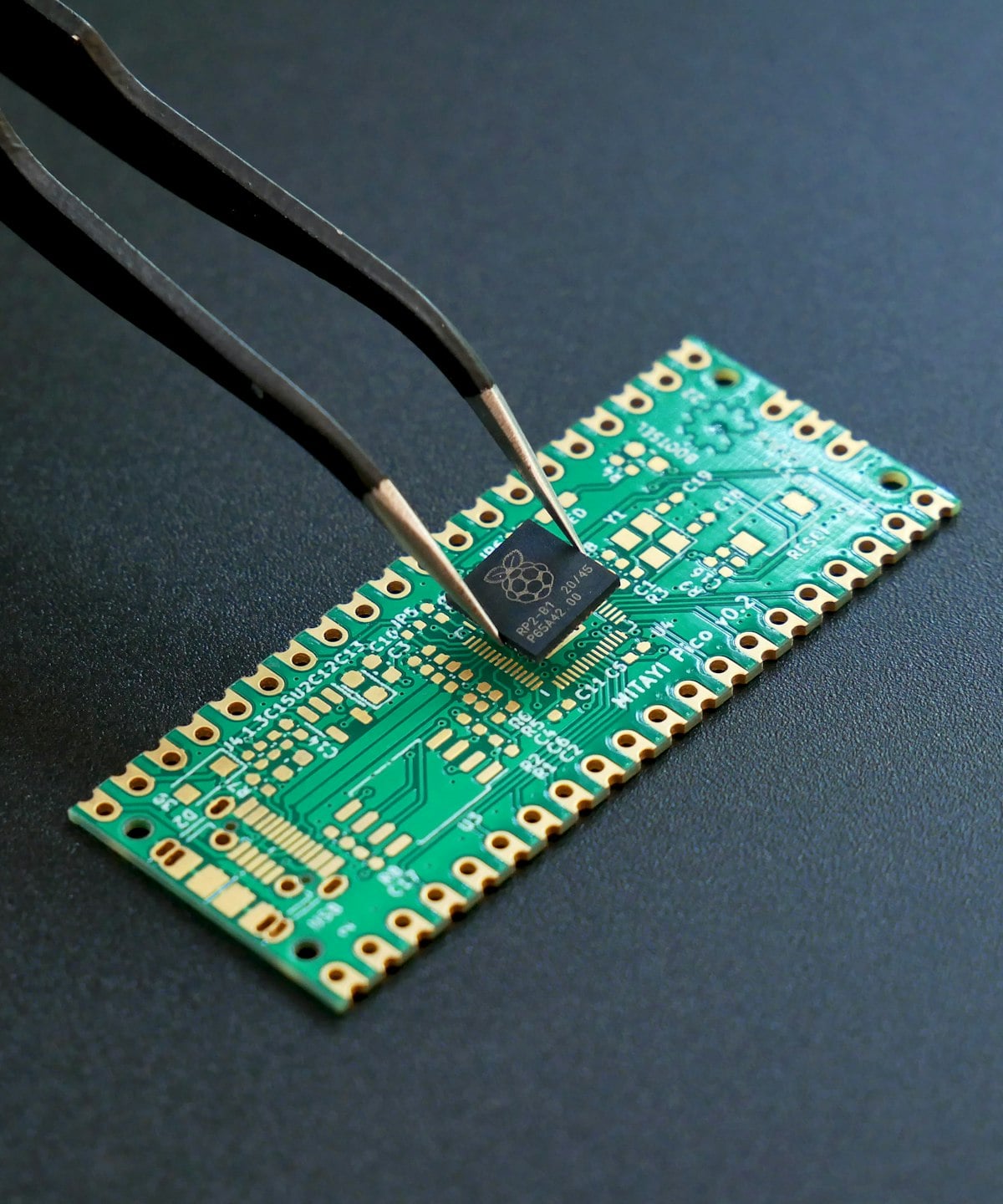 Close-up of an engineer placing a microchip on a printed circuit board